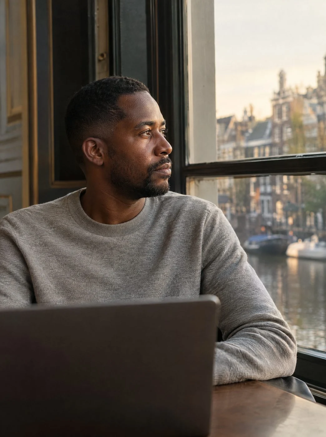 A financial analyst by a canal-house window
